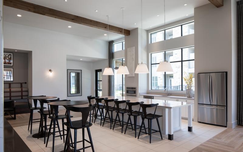 a kitchen with a bar and chairs